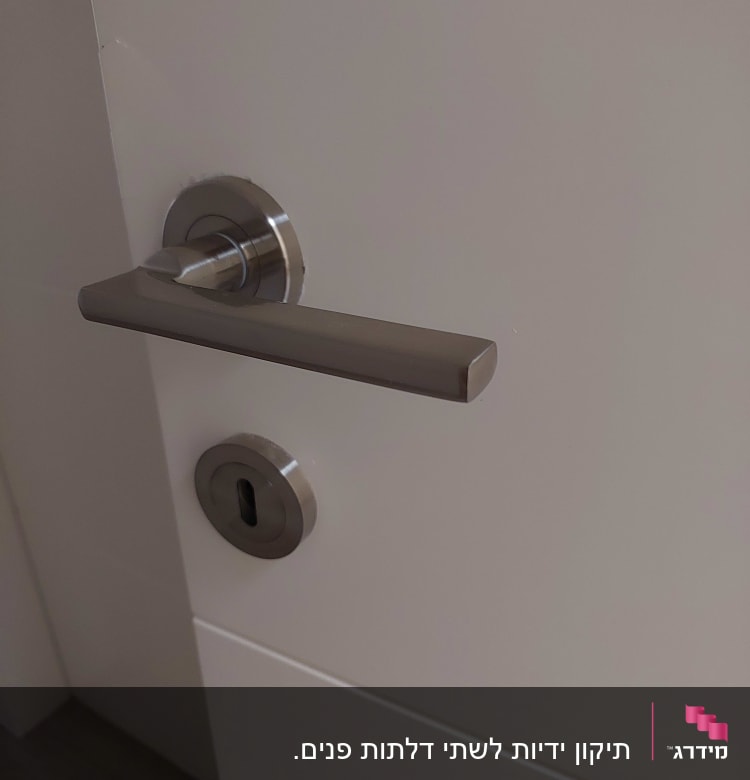 ידית דלת מתכתית ומנעול על דלת לבנה